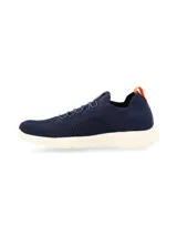 Sneaker azul marino de tejido de punto con cordones elásticos, suela blanca de goma y tirador naranja en el talón.