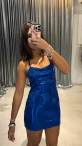 Vestido corto azul con lentejuelas, escote drapeado y tirantes finos.