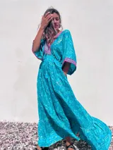 Vestido largo tipo túnica color turquesa con estampado de cachemir y detalles bordados en el escote y las mangas.