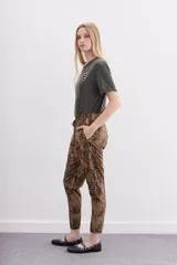 Pantalón babucha con estampado animal print en tonos marrones y negros. Tiene bolsillos diagonales, cintura elastizada y cordón de ajuste.
