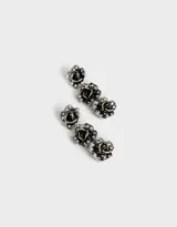 Aros colgantes largos plateados con tres flores y strass.
