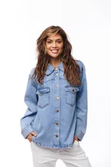 Sobrecamisa celeste de jean con cuello camisero, cierre frontal con botones dorados, dos bolsillos con solapa en el pecho y mangas largas con puños abotonados.