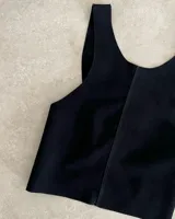 Chaleco color crema de cuero agamuzado con espalda cruzada.