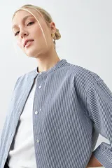 Camisa de jean a rayas verticales azules y blancas, con cuello mao y mangas largas.