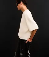Remera oversized de algodón color crudo, con cuello redondo, manga corta, sin estampa y ribete acanalado.