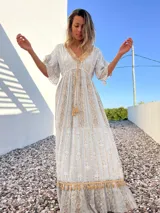 Vestido túnica largo de color celeste con bordados dorados y detalles de encaje en el escote y ruedo.