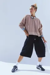 Buzo de tejido de punto color rosa pálido/beige, con largo ligeramente cropped y calce amplio tipo boxy. Presenta detalles de costuras visibles en toda la prenda.