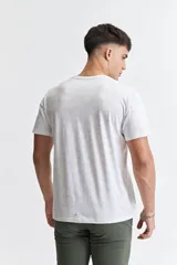 Remera blanca con estampado abstracto en tonos grises, de manga corta, corte regular y cuello redondo.