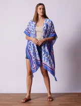 Kimono tejido color naranja con estampado geométrico en blanco y celeste, y terminación con borlas.