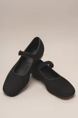 Zapato estilo Mary Jane color marrón, de cuero, con punta redondeada y tira sobre el empeine con hebilla.