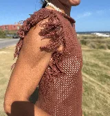 Musculosa tejida color marrón con diseño calado y flecos en los hombros.