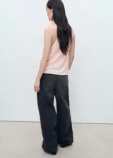 Blusa sin mangas color rosa, con cuello drapeado y detalle de flores en el cuello.