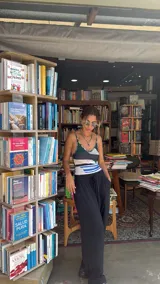 Collar tipo gargantilla compuesto por pequeñas cuentas de acrílico blancas, con dije de cuerno italiano (cornicello) esmaltado en turquesa y adornado con dos piedras rojas redondas. Los herrajes son dorados.