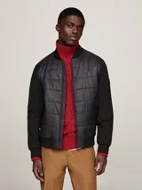 Campera bomber negra con aislamiento térmico y acabado repelente al agua, ideal para conjuntos informales.
