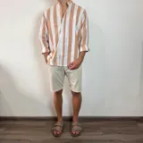 Camisa celeste y blanca a rayas verticales, de lino, con cuello mao y mangas largas con puños.