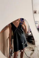 Vestido corto negro de cuero ovino, corte holgado, escote en V y bordado a mano en el frente.