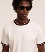 Remera de algodón color crudo con textura vertical, cuello redondo y mangas cortas con rib de color marrón.