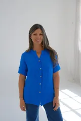 Camisa azul francia de lino con cuello mao y mangas cortas con presilla. Cierre frontal con botones.