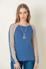 Sweater de lana azul con mangas ranglan color beige.