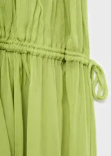Vestido maxi largo de tejido plisado color verde lima, con tirantes finos y fruncido elástico en la cintura.