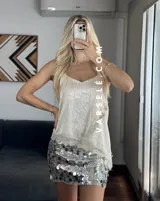 Musculosa lencera blanca con encaje, escote pico y tirantes finos. Bajo asimétrico.