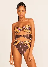 Conjunto de bikini Triya con estampado floral en tonos marrones, naranjas y violetas. El corpiño es strapless con nudo central y la bombacha es de tiro alto con aberturas laterales.