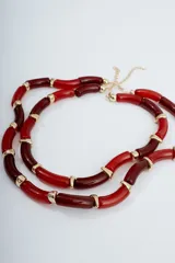 Collar corto de cuentas tubulares rojas y borgoña alternadas con detalles dorados.