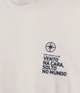 Remera de algodón color crema, de corte recto, con cuello redondo y mangas cortas. Estampa en el pecho con lettering "vento na cara, solto no mundo".