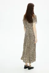 Vestido midi de corte recto con estampado de leopardo, cuello redondo y mangas cortas. Tiene cierre oculto en la espalda.