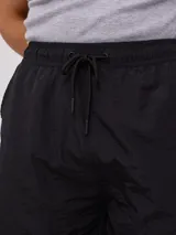 Bermuda color beige de corte recto con bolsillos cargo laterales y cintura elastizada con cordón ajustable.