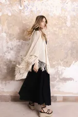 Capa tejida color negro, con flecos largos en los bordes.