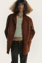Blazer de cuero color marrón, con cuello solapa de muescas y manga larga. Tiene bolsillos con solapa en delantero, forro interior y cierre frontal con botones.