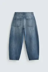 Pantalón de jean azul de corte amplio, con roturas y lavado gastado.