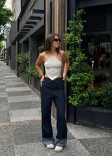 Top tejido a crochet color gris claro, con diseño asimétrico y tirantes finos.