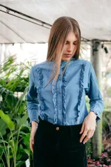 Camisa celeste de manga larga con cuello mao y volados en el frente.