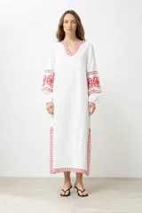 Túnica larga color crudo con bordados rojos en cuello, mangas y ruedo.