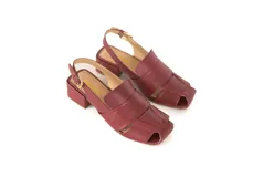 Sandalia de cuero color borgoña, con punta cuadrada y tiras anchas entrecruzadas. Tiene talón abierto con pulsera ajustable y taco ancho forrado de 4 cm.