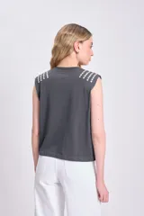 Remera musculosa gris claro con cuello redondo y apliques de strass en los hombros.
