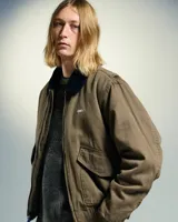 Campera marrón de algodón con cuello de pana negro, cierre frontal con cremallera, dos bolsillos delanteros con solapa y puños y cintura elastizados.