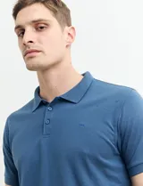 Chomba azul marino con pequeños lunares blancos, cuello clásico con botones y mangas cortas.