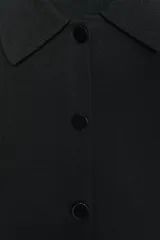 Chaqueta corta negra de punto con cuello solapa, manga larga y cierre frontal con botones.
