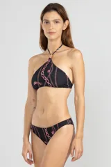 Top de bikini estilo halter confeccionado en tejido reciclado, color negro con estampado de cadenas rosas y detalle de flor en el cuello.