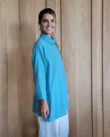 Camisa celeste de corte amplio, con cuello clásico y mangas largas.