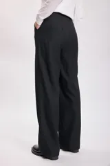 Pantalón de vestir color beige, de corte ancho y tiro alto.