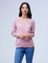 Buzo de hilado fino color rosa con detalle bordado y calado en la parte delantera, de manga larga.