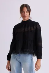 Blusa negra con cuello alto y mangas largas, con detalles de encaje en el pecho, mangas y ruedo.