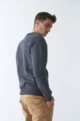 Buzo de felpa gris oscuro con logo estampado en el frente, cuello redondo, mangas largas y puños.