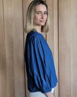 Camisa de mangas largas abullonadas con puños elásticos, cuello redondo y cierre frontal con botones.