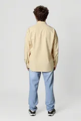 Camisa blanca de manga larga con cuello clásico y cierre frontal con botones.