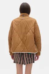 Campera acolchada color crema con cierre frontal y cuello alto. Presenta dos franjas azules en las mangas y ribete azul en el cuello y ruedo.